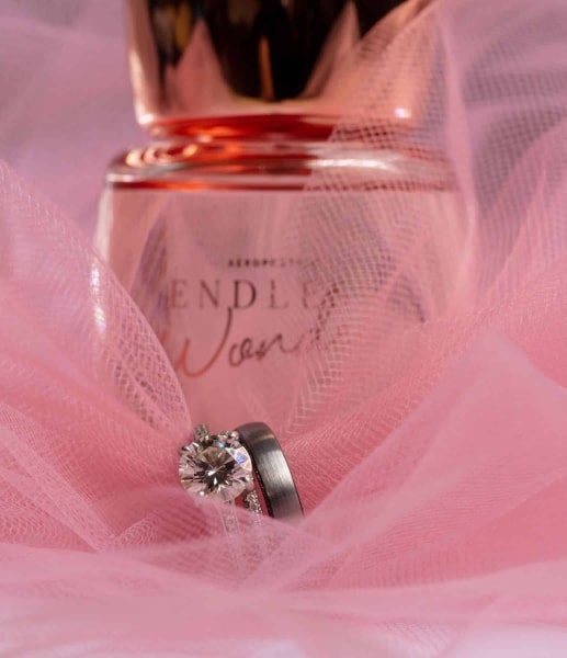 wedding-rings-in-pink-fabric-with-perfume-bottle