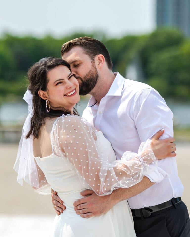 Couple's photography service in Cleveland, boyfriend kissing her on the cheek.